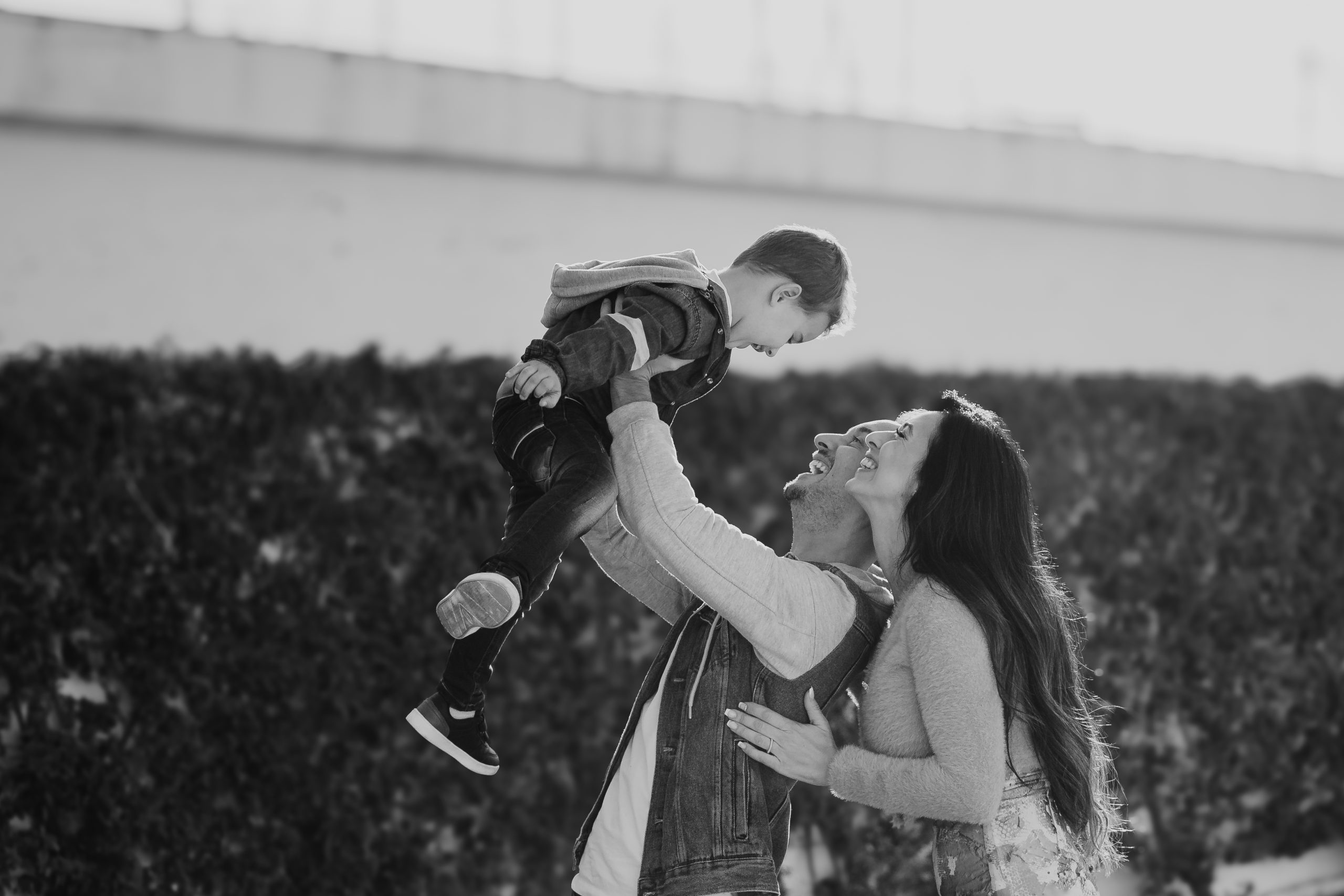 Padre abrazando a su hijo pequeño en una sesión de fotografía familiar natural en Barcelona