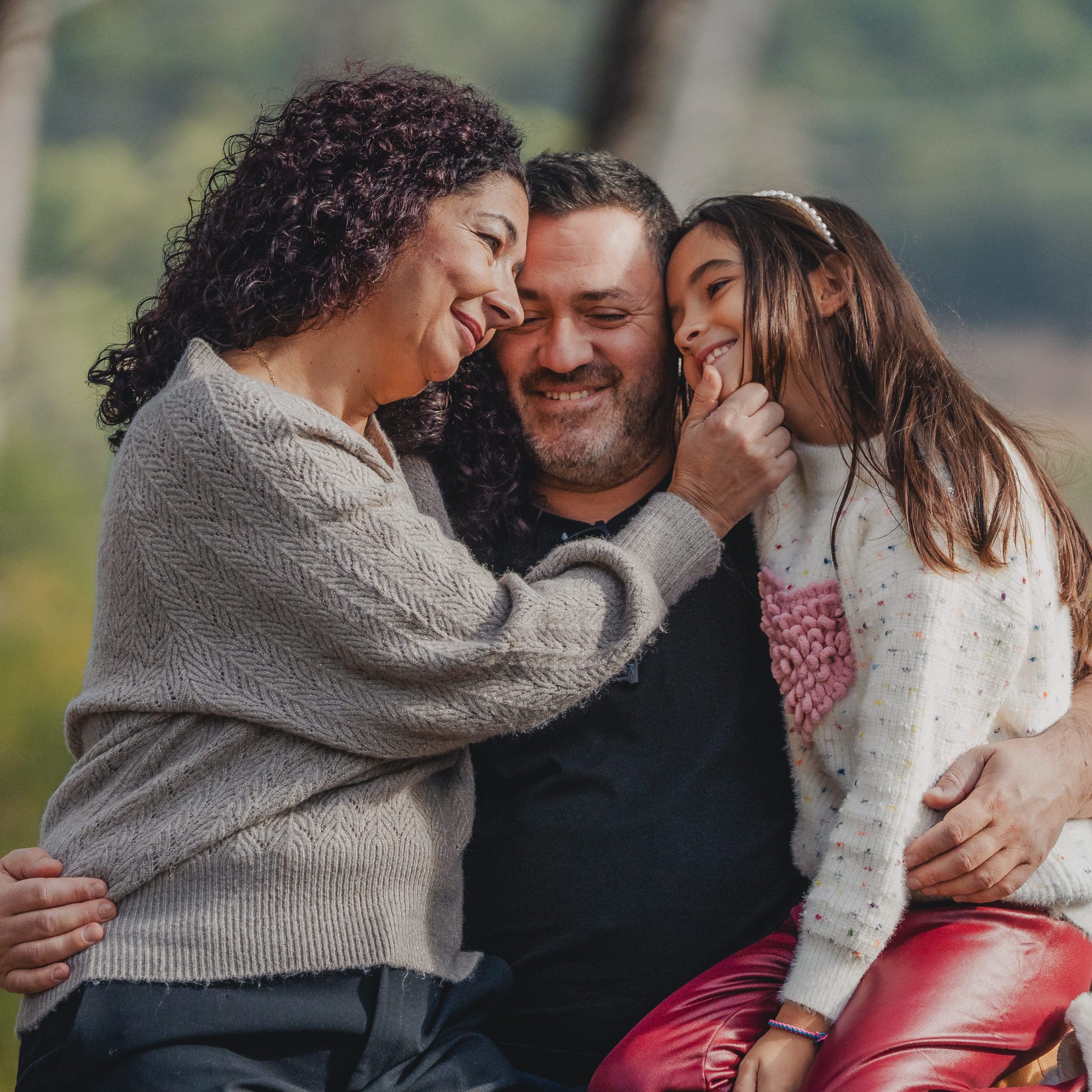 Familia abrazándose durante una sesión de fotos familiar natural al aire libre en Barcelona