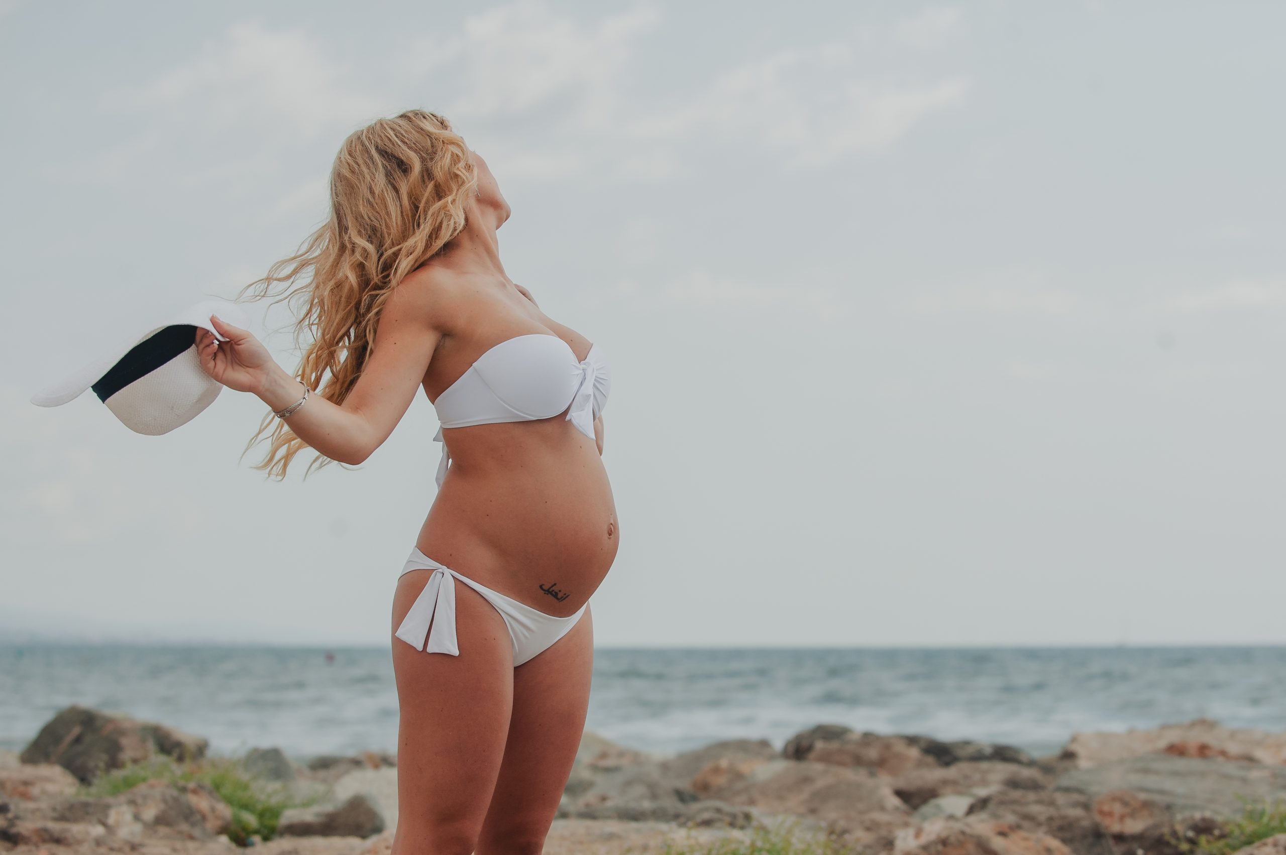 Sesión de embarazo en la playa de Barcelona con pareja esperando su bebé